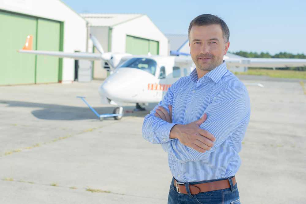 a private jet owner standing in front of his aircraft