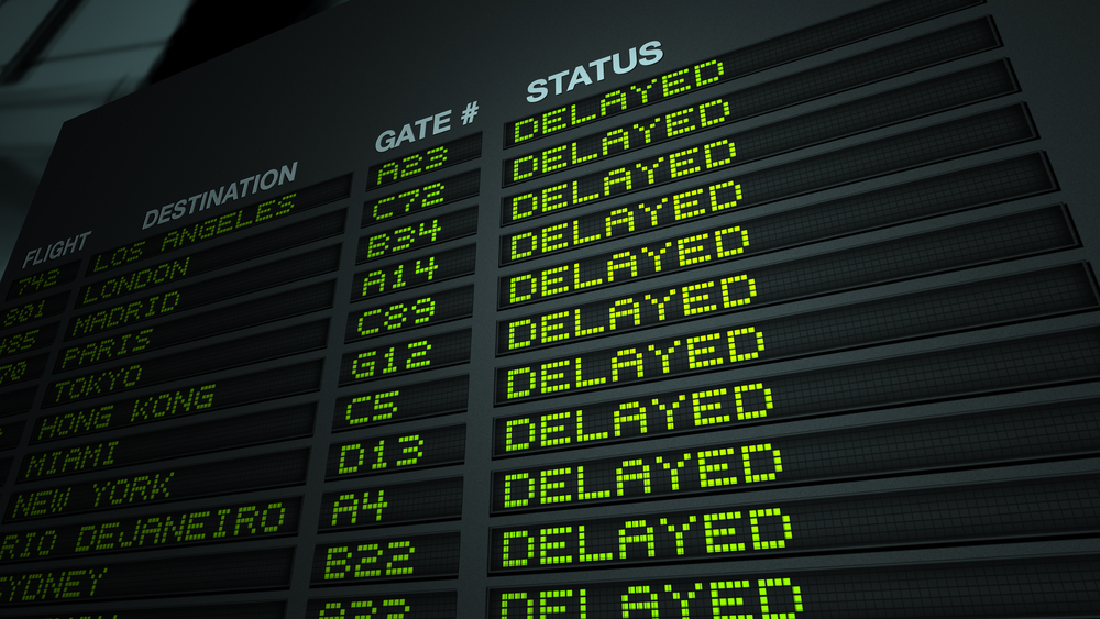 a departures board at an airport showing delayed flights