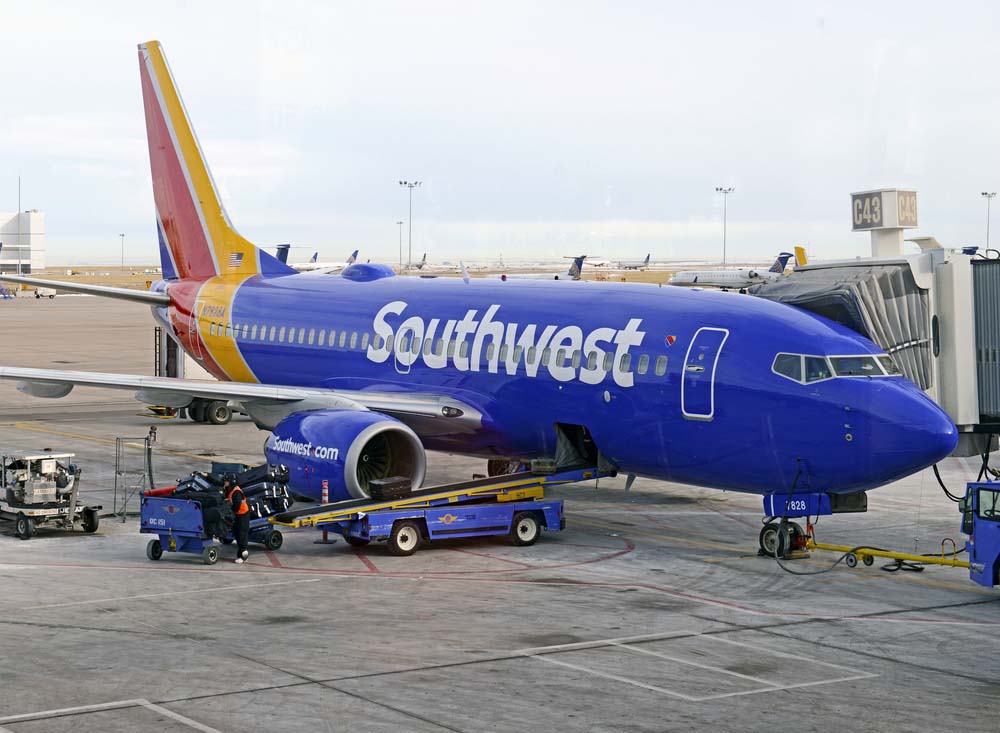 a Southwest Airlines aircraft loading baggage, catering, and passengers