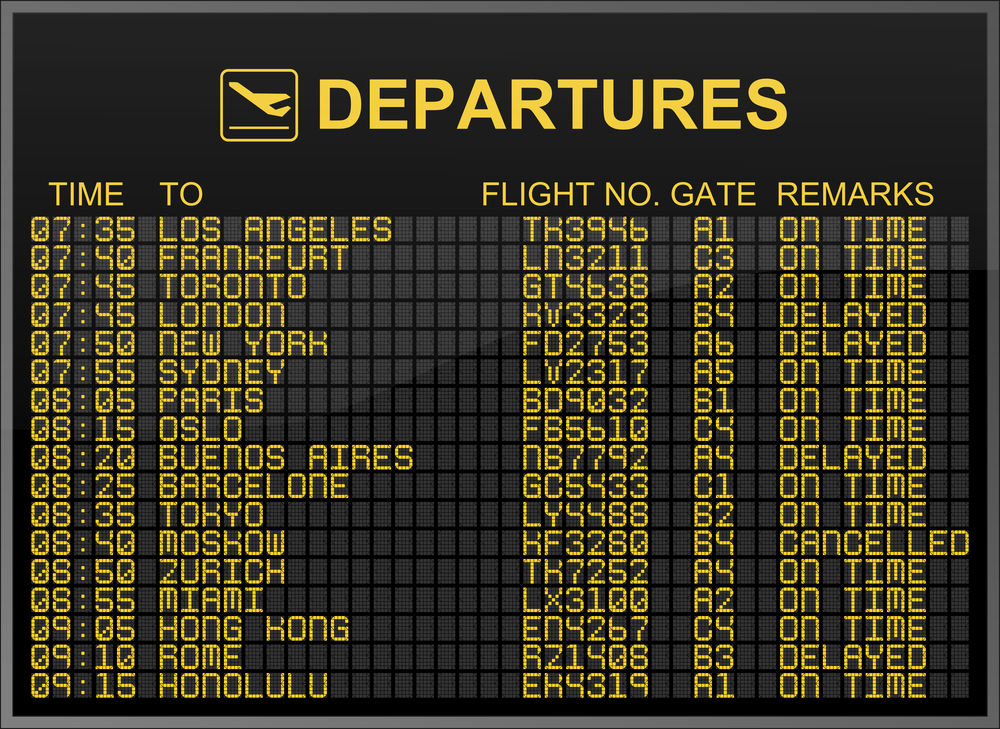 an airport departures board showing commercial flight times