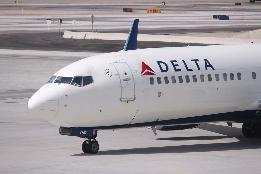 A white plane bearing the Delta logo on the tarmac.
