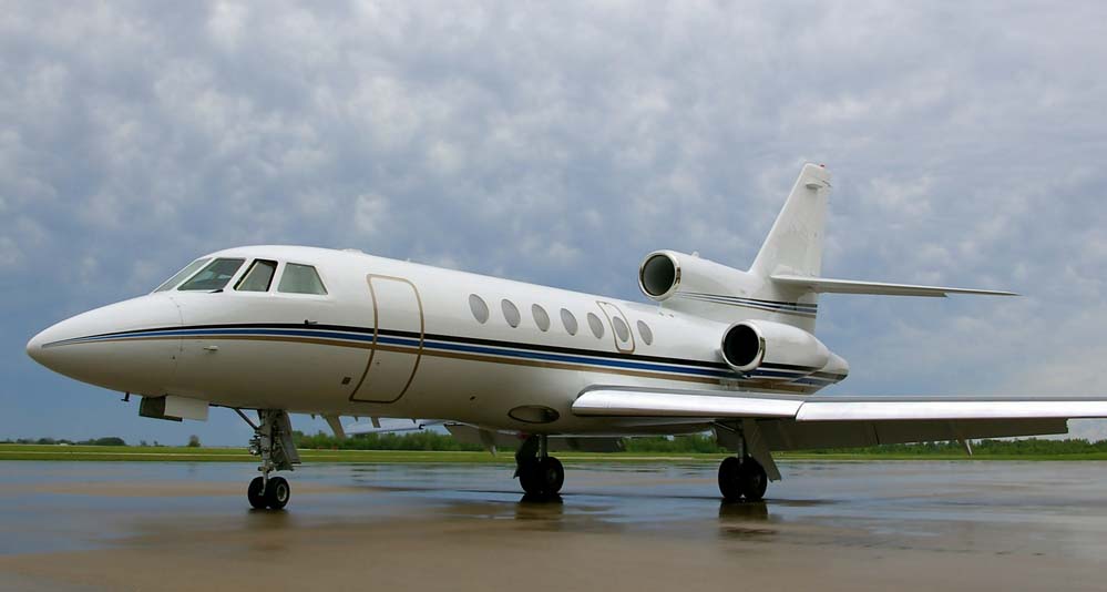 a private jet on a tarmac on a cloudy and rainy day